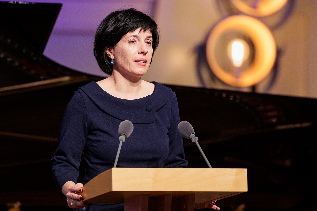 Представительница литовского правительства выступает на трибуне во время официального мероприятия