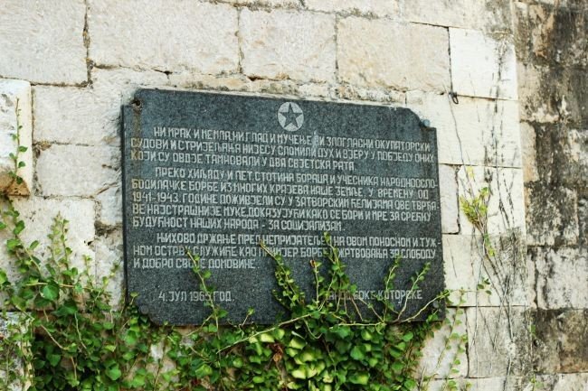 Мемориальная доска на стене крепости Мамула в память о жертвах концентрационного лагеря времён Второй мировой войны