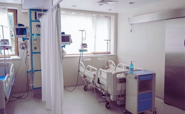 Больничная палата с медицинским оборудованием и койками, разделёнными шторами