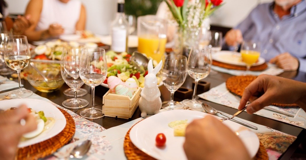 Праздничный пасхальный стол с традиционными блюдами, крашеными яйцами и весенними цветами