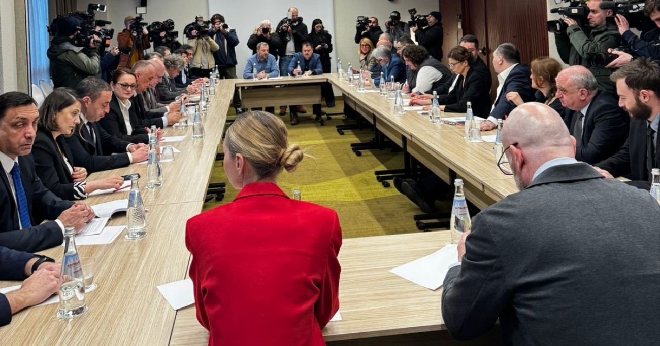 High-level political meeting at conference table with press in attendance. Фото: JAM News