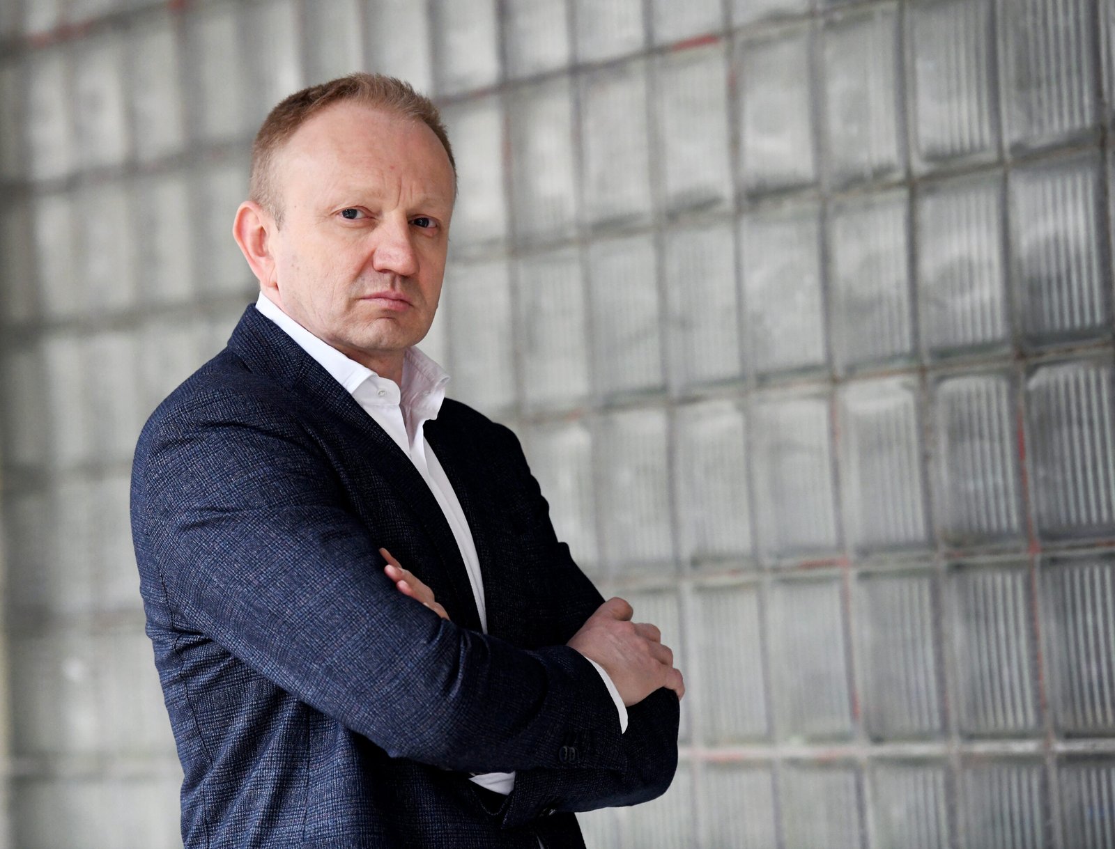 Politician with crossed arms against glass block wall. Фото: N1 Info
