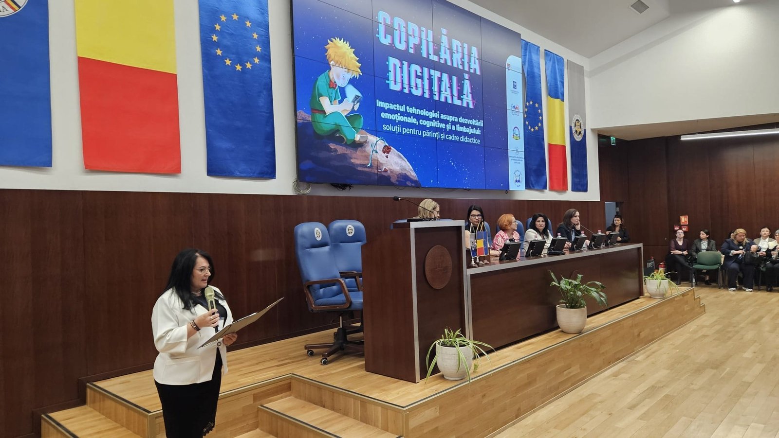 Спикер выступает на конференции «Copilăria Digitală», посвящённой цифровой безопасности детей, перед панелью экспертов