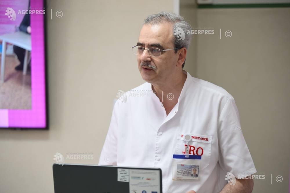 Врач в белом халате работает за ноутбуком в больничном кабинете