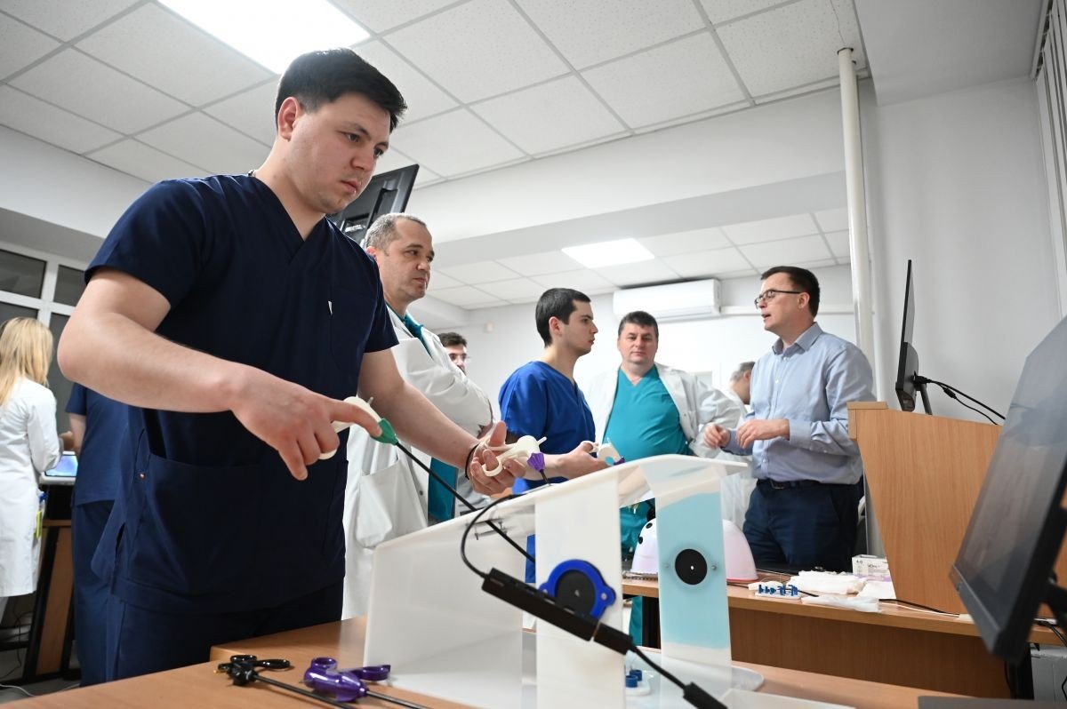 Врач-резидент выполняет урологические манипуляции на симуляционном оборудовании под наблюдением коллег и преподавателей