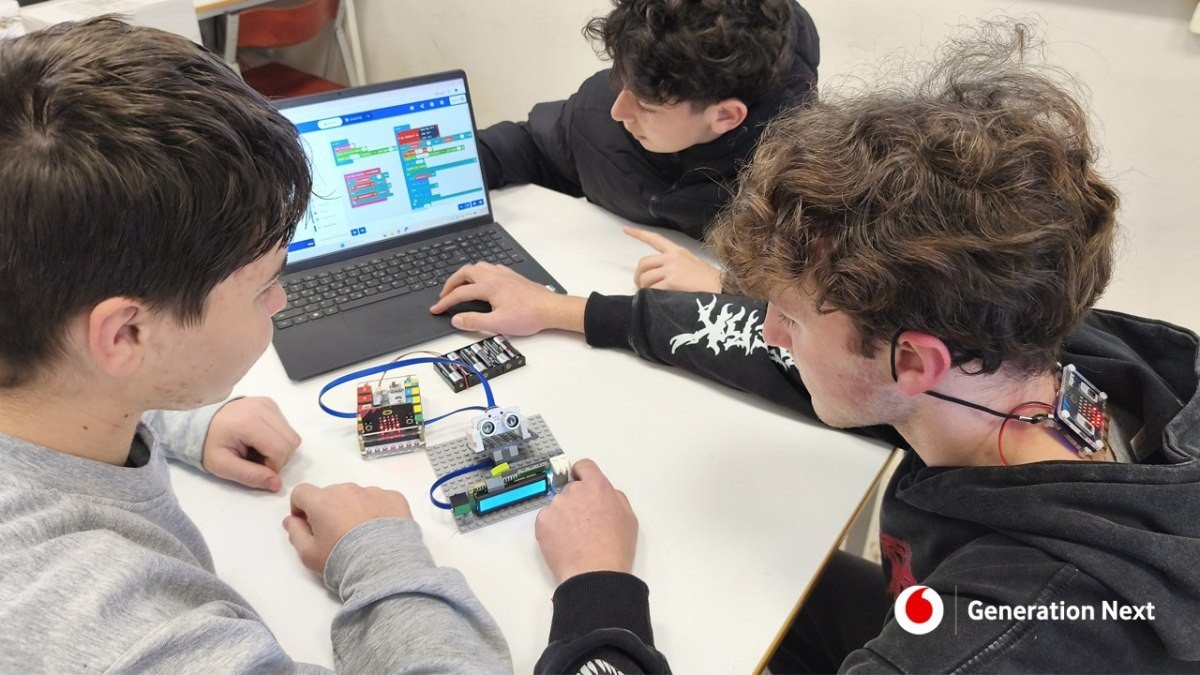 Ученики команды Micro-Posture программируют устройство для коррекции осанки на базе Arduino — на столе ноутбук и электронные компоненты