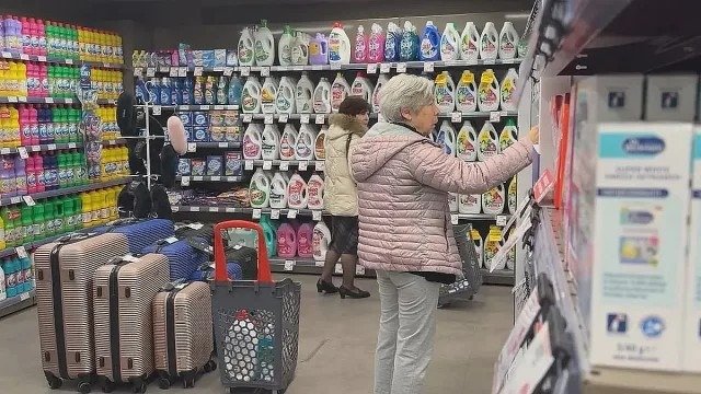 Покупатели выбирают товары на полках магазина с бытовой химией