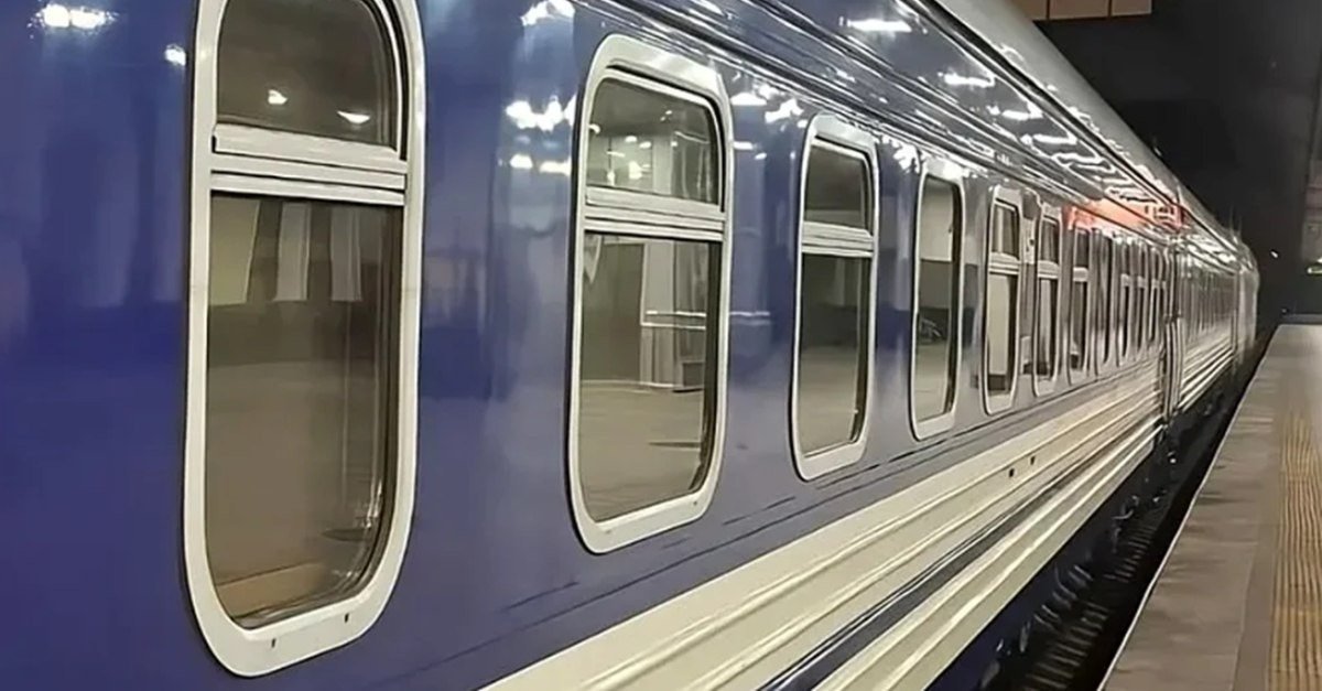 Синий пассажирский поезд на платформе железнодорожного вокзала в ночное время