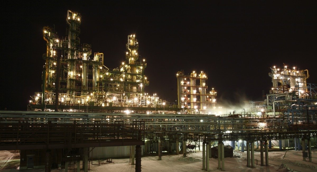 Нефтегазоперерабатывающий комплекс в ночное время, освещённый промышленными огнями