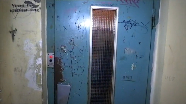 Лифты Белграда: 43 года вместо положенных 25 Обшарпанная голубая дверь лифта с граффити в белградском жилом доме