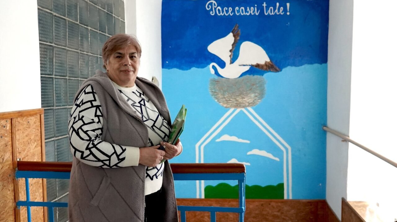 Школьный библиотекарь Людмила Костенко в Паланке на фоне мурала с надписью «Мир твоему дому». Фото: Unknown