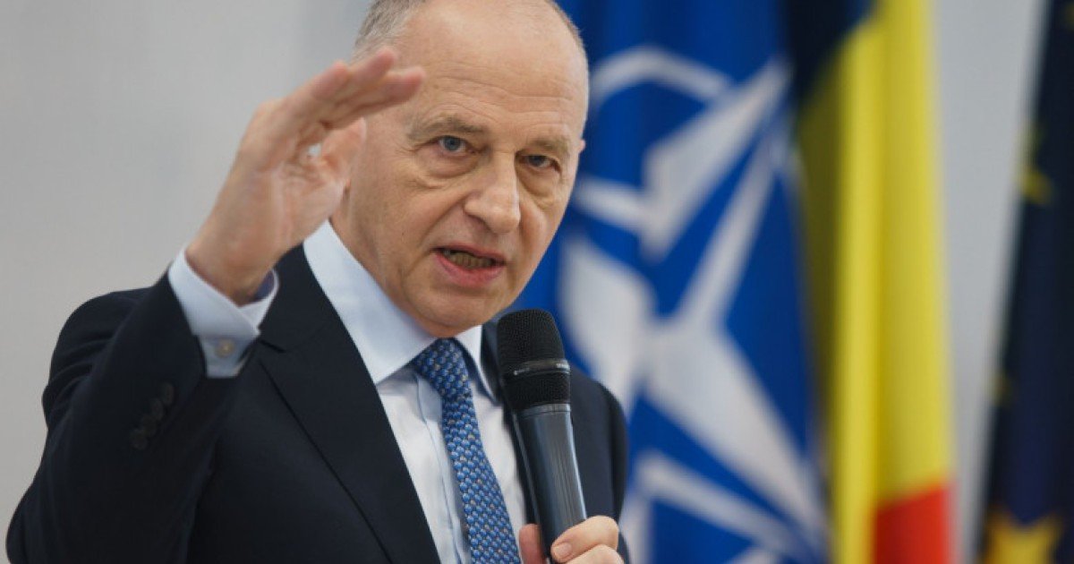 Мирча Джоанэ, бывший заместитель генсека НАТО, выступает на фоне флагов НАТО и Румынии