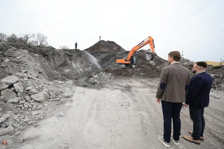 Городские чиновники наблюдают за ходом санации золоотвала «Энергетики»: экскаватор разбивает затвердевшую золу, территорию орошают водой для подавления пыли