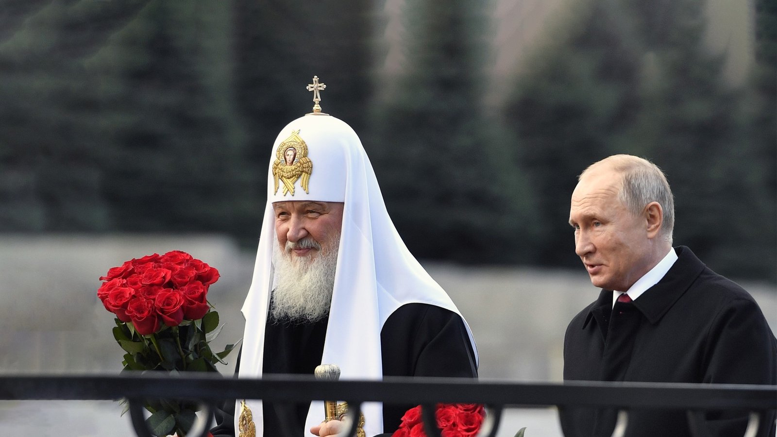 Президент России Владимир Путин и Патриарх Московский Кирилл с букетами красных роз на публичной церемонии