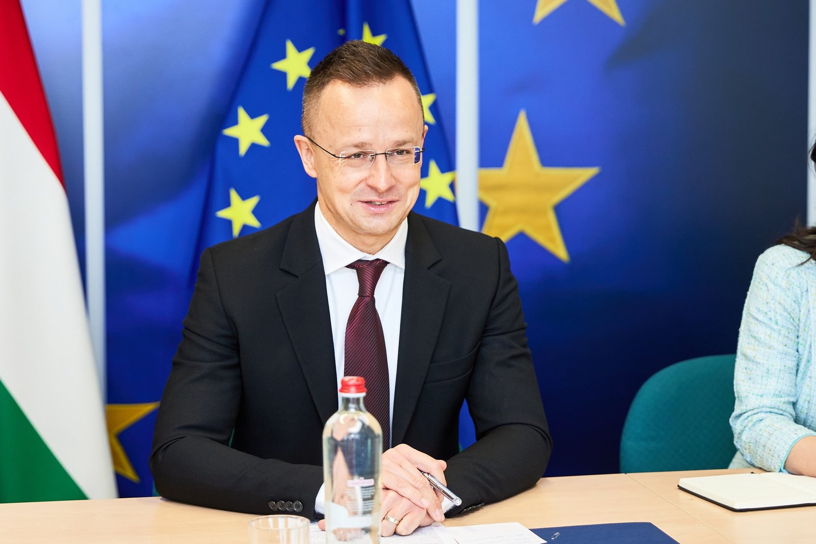 Петер Сийярто на фоне флагов Венгрии и ЕС