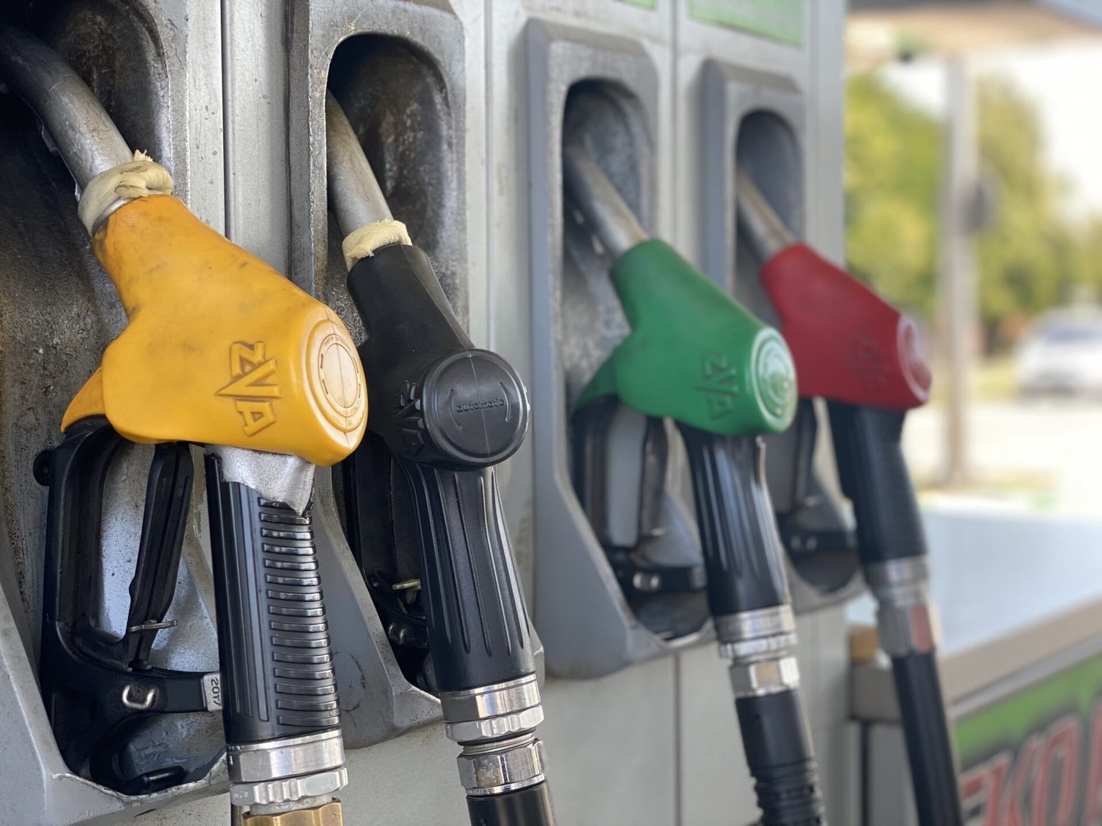 Разноцветные топливные пистолеты на автозаправке крупным планом