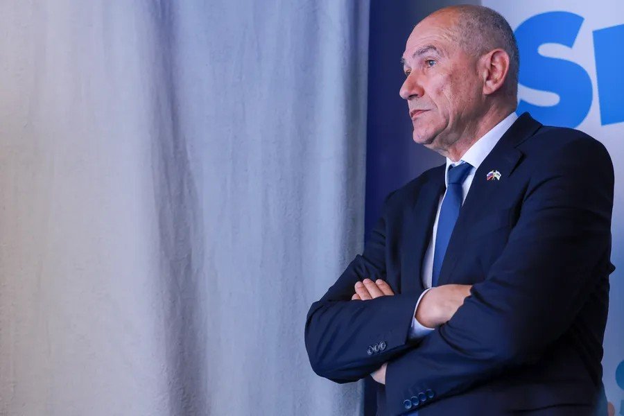 Лидер оппозиционной словенской партии SDS Янез Янша стоит со скрещёнными руками на партийном мероприятии