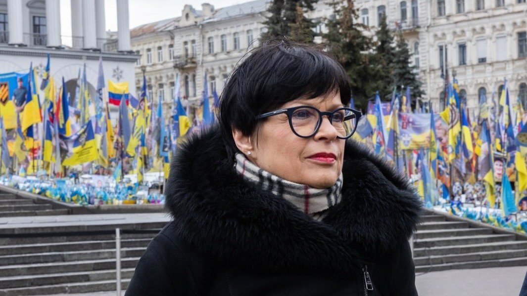 Марта Кос во время визита в Киев на фоне украинских флагов и мемориала