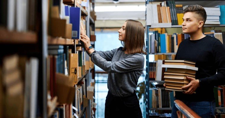 Молодые библиотекари за работой с книжными фондами — сфера культуры теряет специалистов из-за низких зарплат