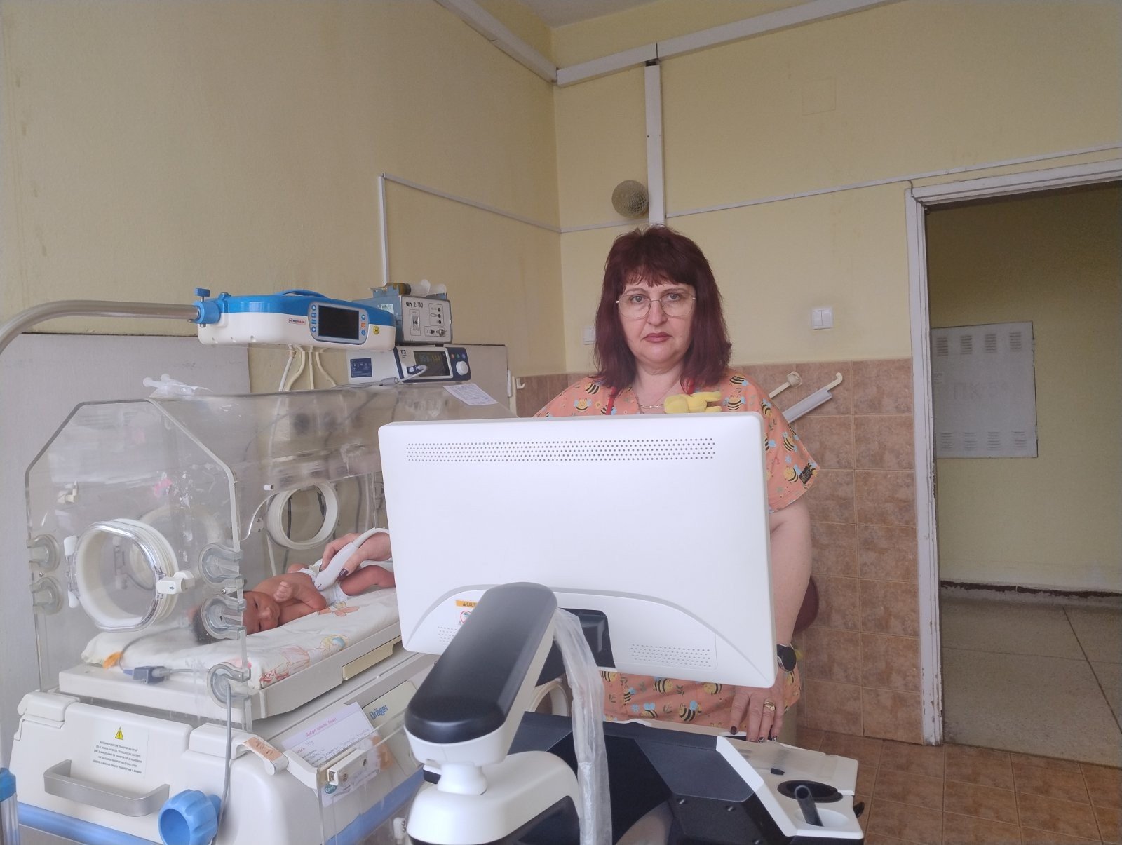 Врач-неонатолог с аппаратурой мониторинга и инкубатором в отделении неонатальной помощи больницы Шумена