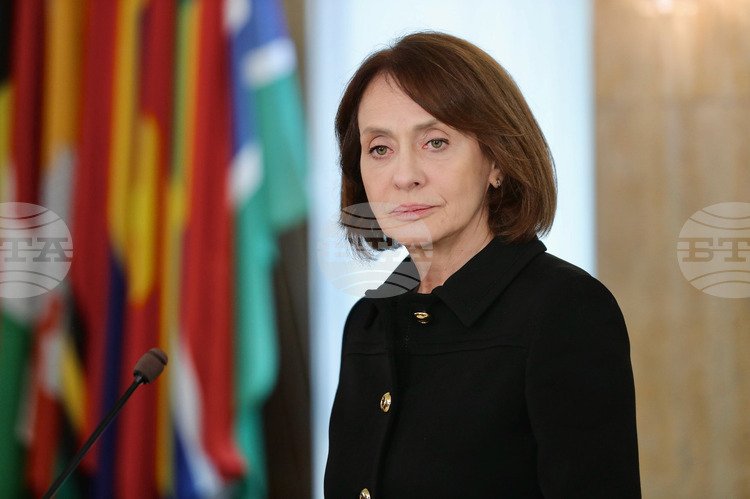 Министр иностранных дел Нейнски на дипломатическом мероприятии с международными флагами. Фото: Unknown