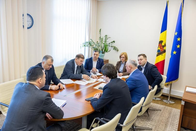 Official government meeting in Moldova with officials seated around a conference table, Moldova and EU flags visible in the background. Фото: MoldPres