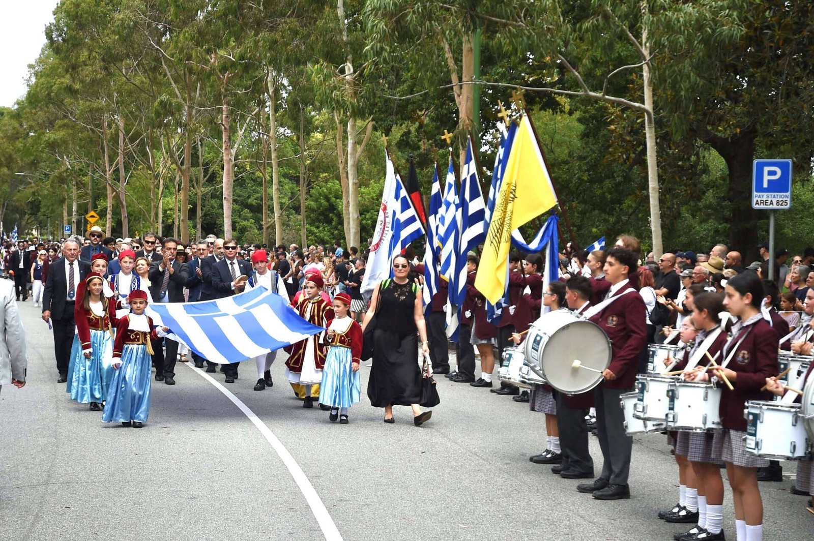 Колонна парада с греческими флагами и барабанщиками на широком проспекте Мельбурна