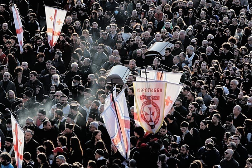 Верующие с церковными хоругвями у Кафедрального собора Святой Троицы в Тбилиси во время прощания с Патриархом Илией II