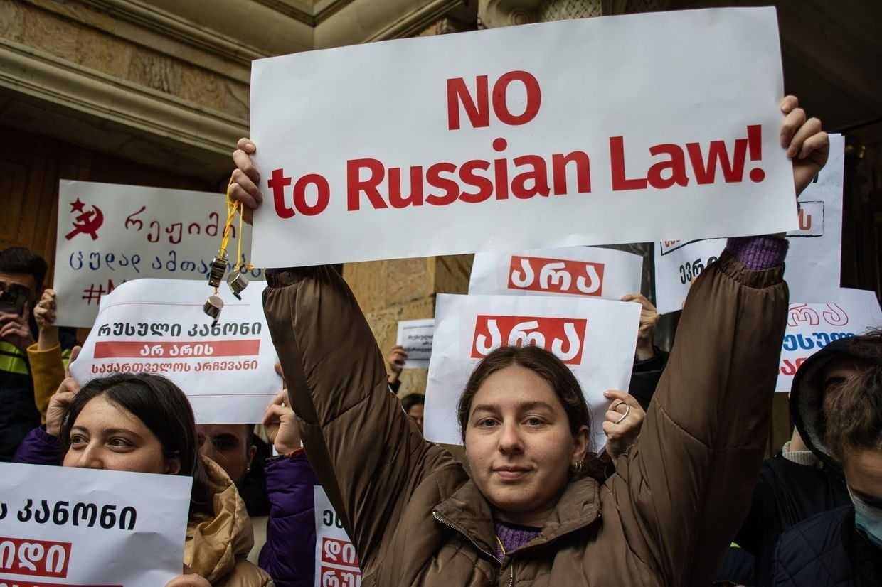 Участники акции протеста в Тбилиси с плакатами «NO to Russian Law!» на английском и грузинском языках во время демонстрации против закона об иноагентах