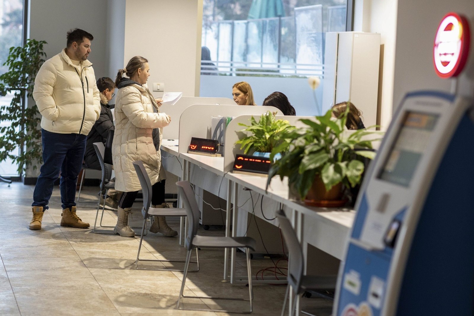 Граждане обращаются в приёмное окно государственного учреждения в Румынии — именно такие структуры затронет сокращение штатов в рамках реформы Боложана