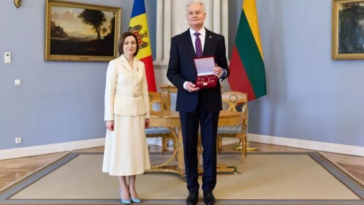 Майя Санду и Гитанас Науседа во время церемонии награждения между флагами Молдовы и Литвы