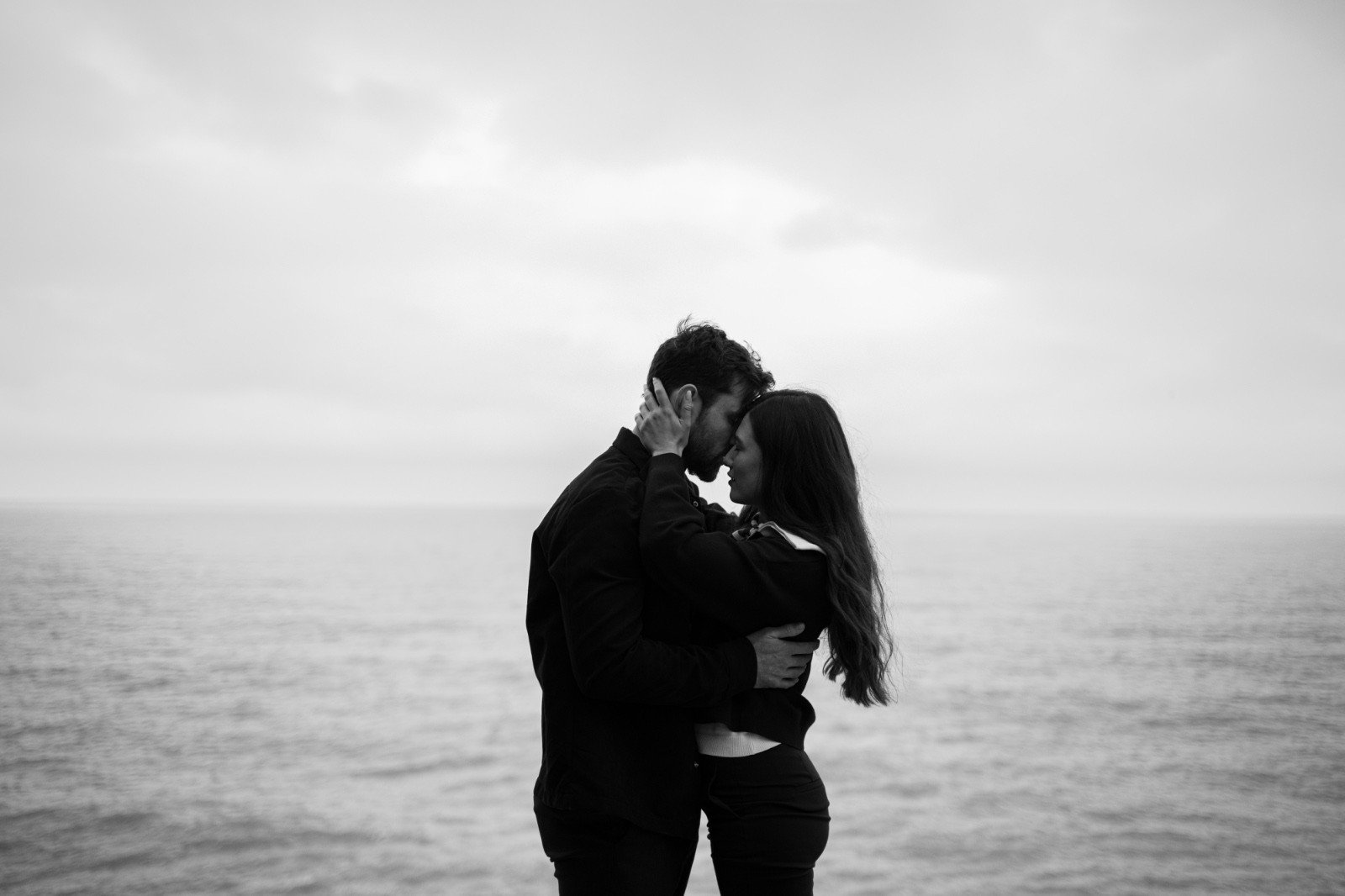 Чёрно-белый кадр из фильма — пара обнимается на фоне моря