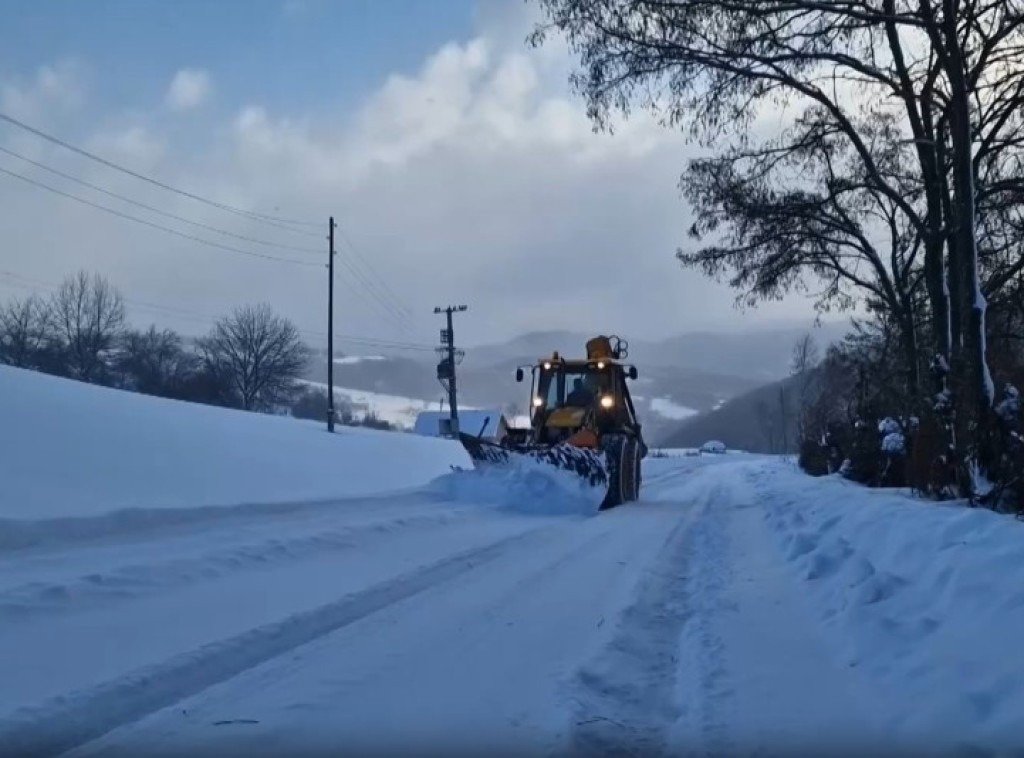 Снегоуборочная машина расчищает заснеженную дорогу в горах