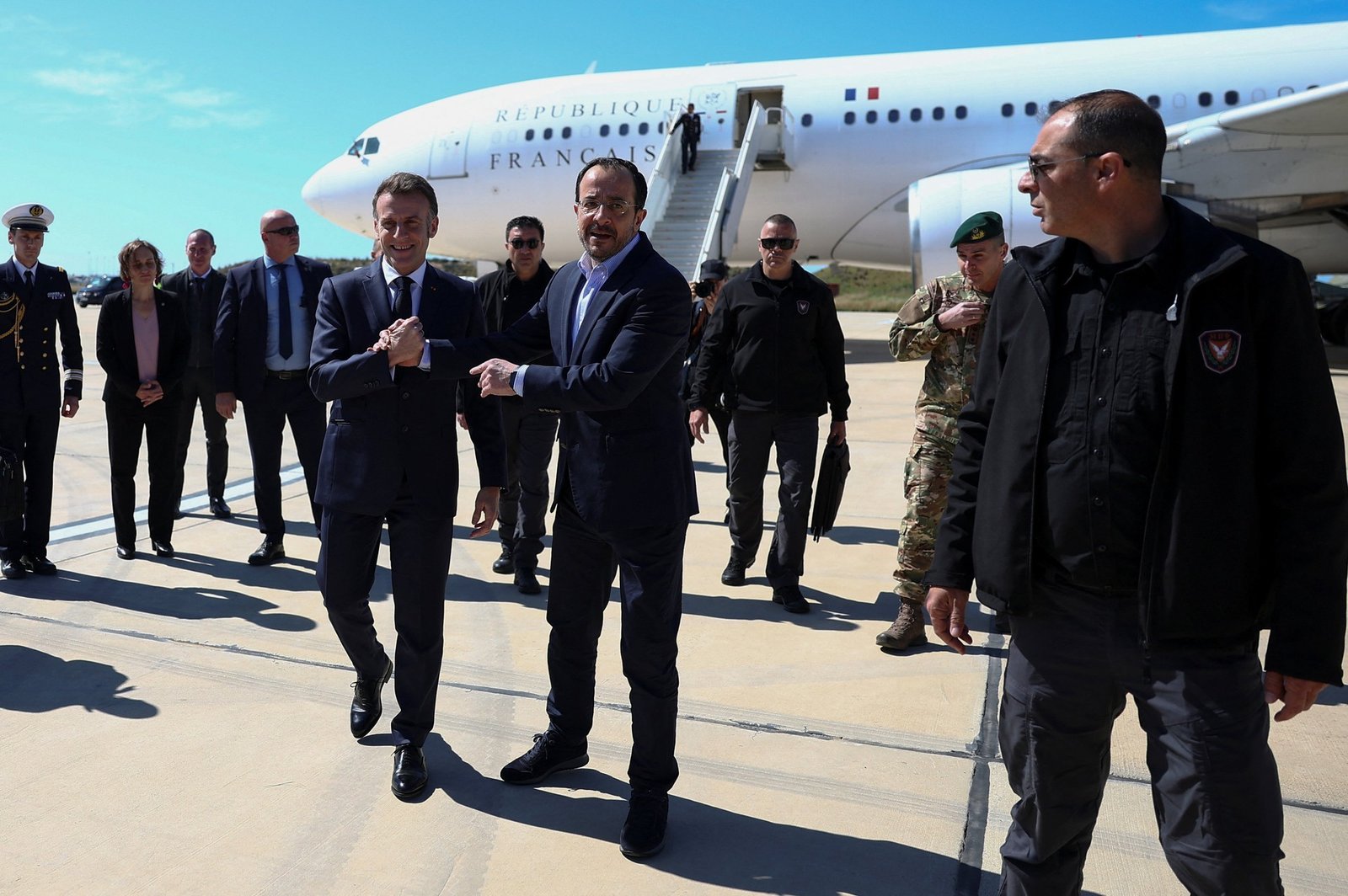 Президент Макрон приветствует президента Христодулидиса на лётном поле аэропорта Пафоса на фоне самолёта Французской Республики
