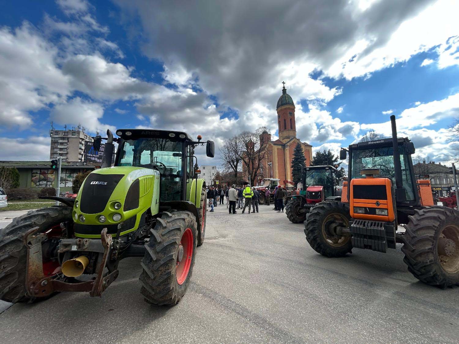 Тракторы на городской площади с православным храмом на заднем плане