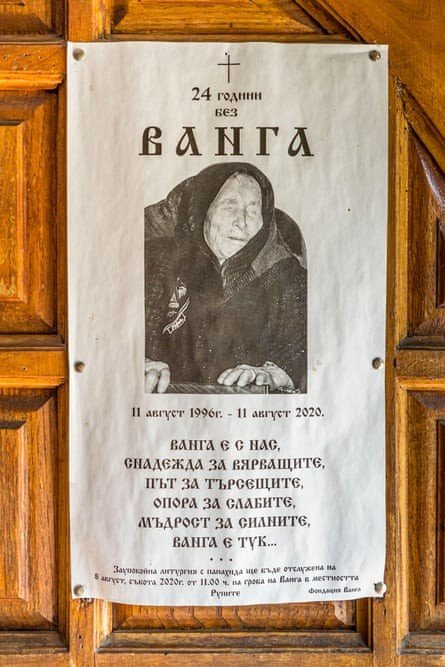 Memorial poster on a wooden door: '24 години без ВАНГА' with her portrait and tribute text in Bulgarian. Фото: The Guardian