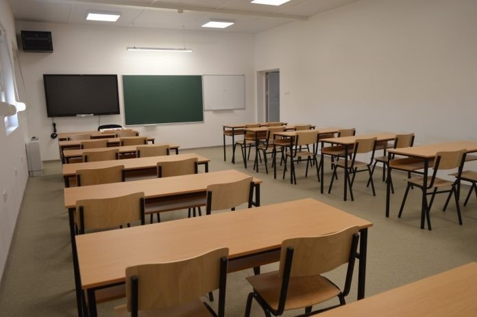 Пустой школьный класс в Косово с рядами парт и доской