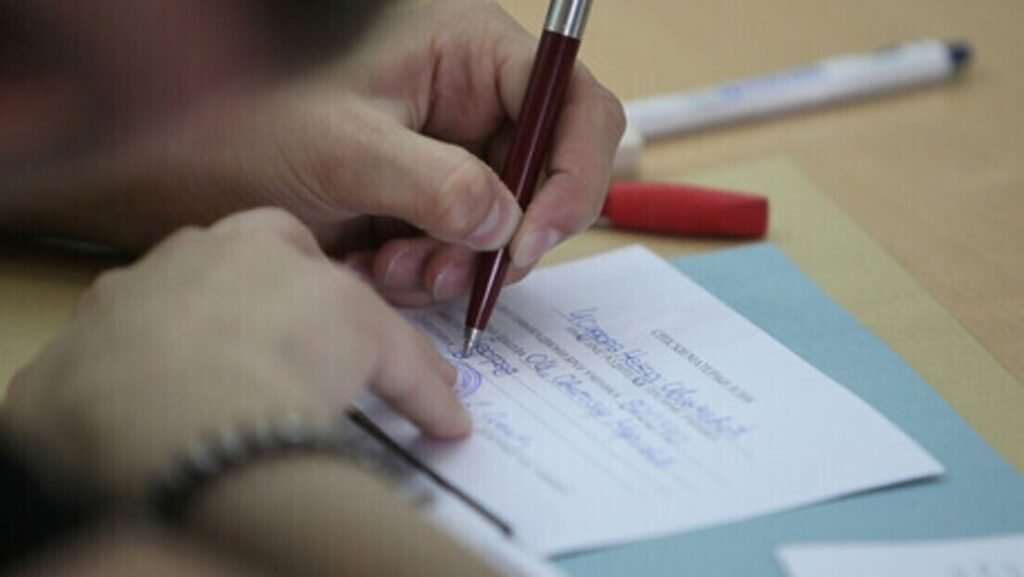 Ученик заполняет бланк ответов на экзамене в школе