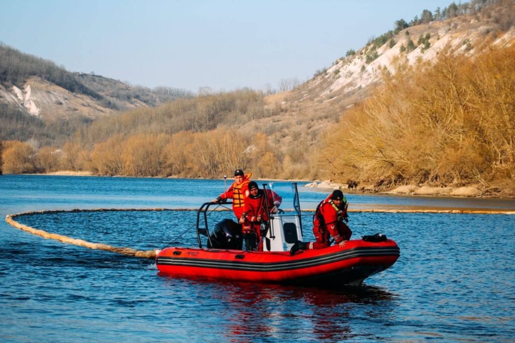 Спасательная лодка с боновым заграждением на реке Днестр во время ликвидации разлива нефтепродуктов