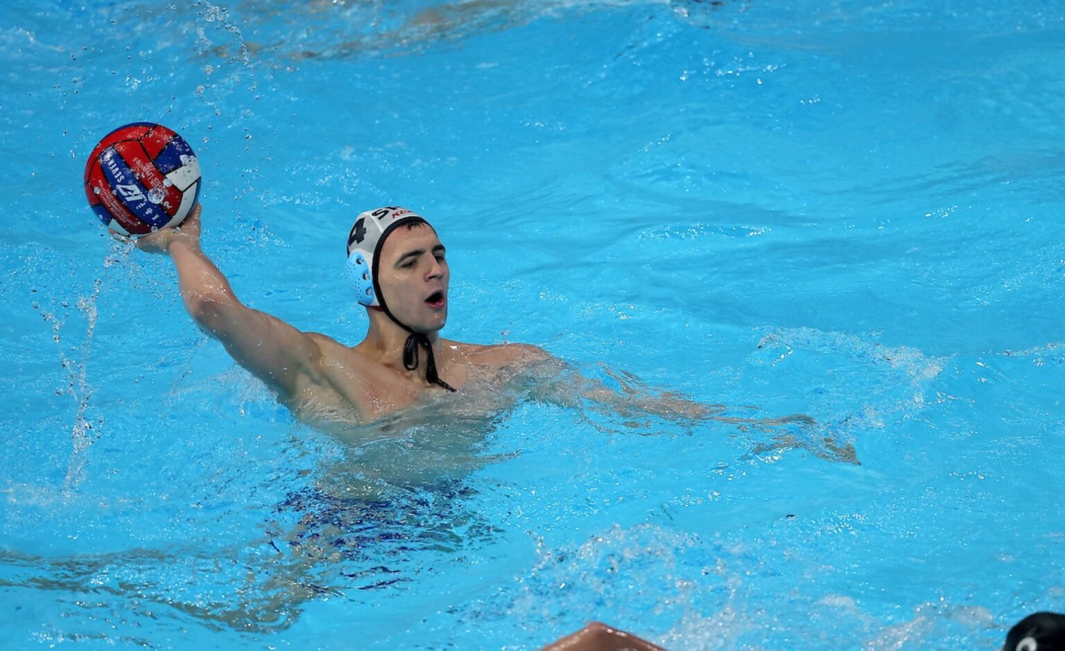 Игрок сборной Сербии с мячом во время матча квалификации Кубка мира по водному поло