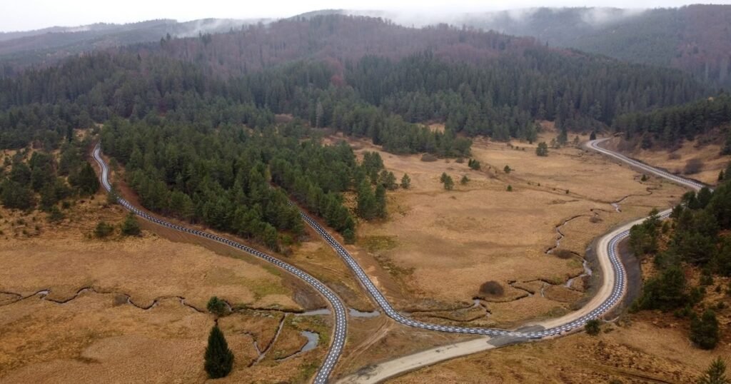 Аэросъёмка велосипедной дорожки, петляющей через горный ландшафт в Мунций-Пояна-Рускэ, район Хунедоара
