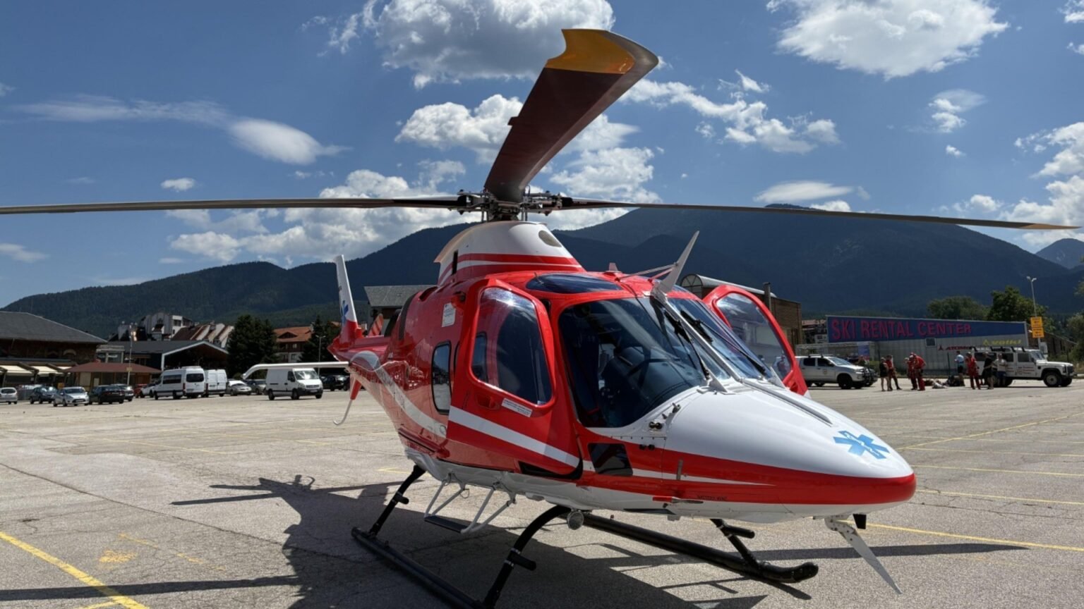 Воздушная скорая прилетела в Русе, но пациента не эвакуировали Красный медицинский вертолёт на лётной площадке на фоне горного пейзажа