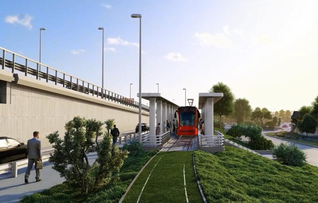 3D-визуализация остановки трам-трейна в Орадя: красный вагон на озеленённых путях рядом с автомобильной эстакадой