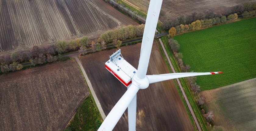 Вид сверху на ступицу и лопасти ветровой турбины Vestas над полями — визуальная иллюстрация к 70-мегаваттному проекту Стражица в Болгарии