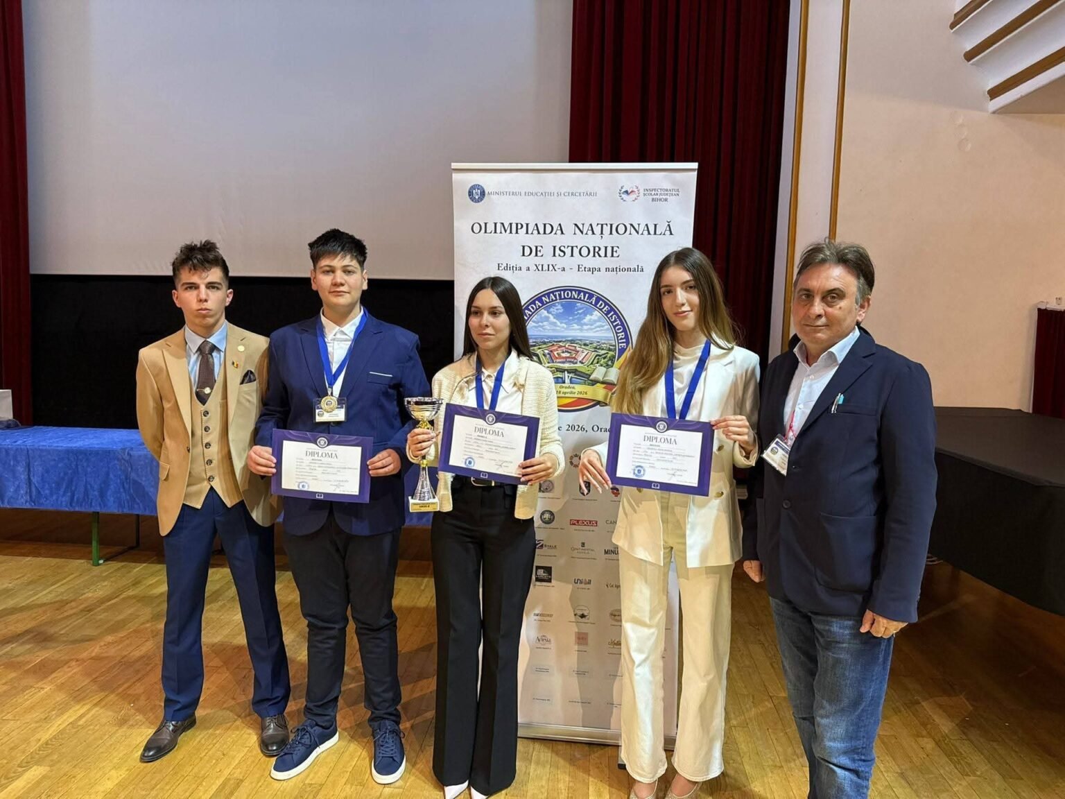 Четверо школьников из Горжа с дипломами и кубком вместе с учителями после награждения на национальной олимпиаде по истории в Ораде