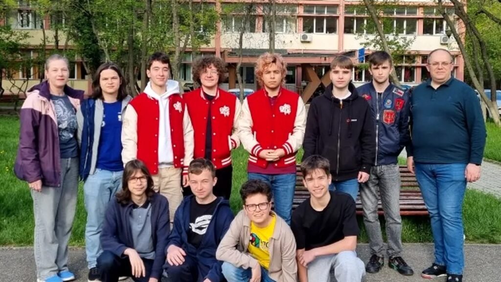 Школьники-информатики из Ясс вместе с тренерами после призовых мест на международном турнире IATI 2026: команда в фирменных куртках-«варсити» позирует во дворе Национального колледжа