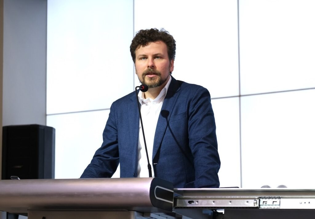 Дан Перчун у трибуны с микрофонами во время выступления