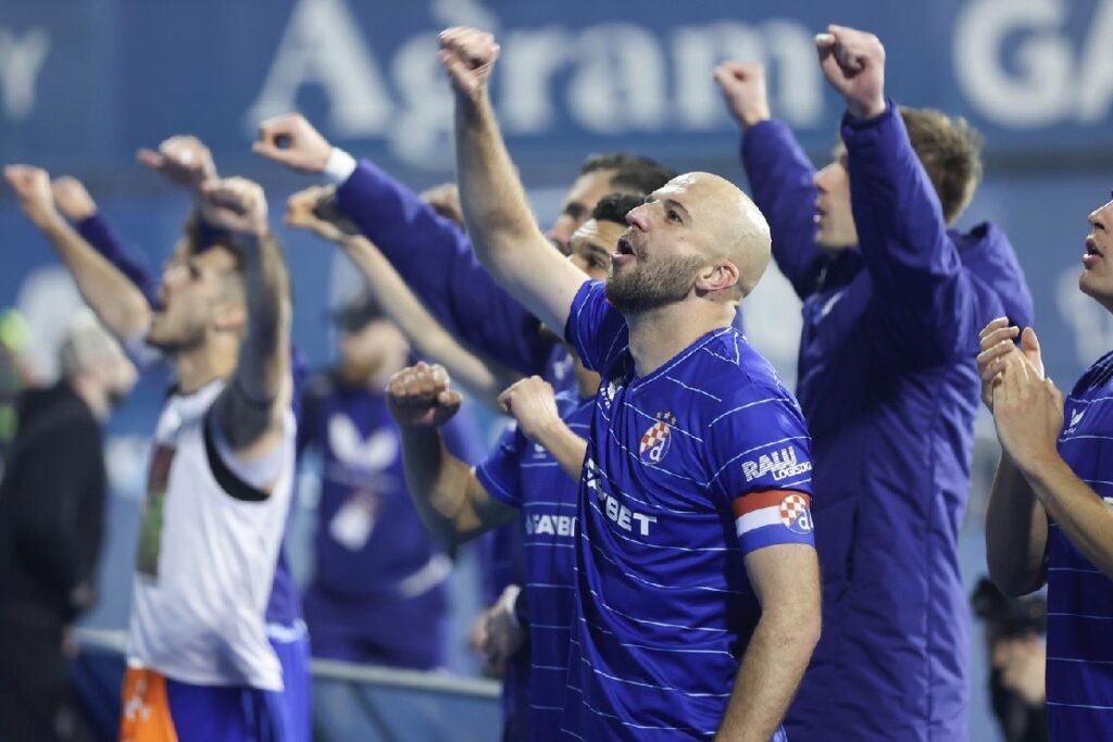 Футболисты загребского «Динамо» в синих клубных футболках поднимают кулаки и приветствуют трибуну на «Максимире» после очередной победы по ходу сезона SuperSport HNL