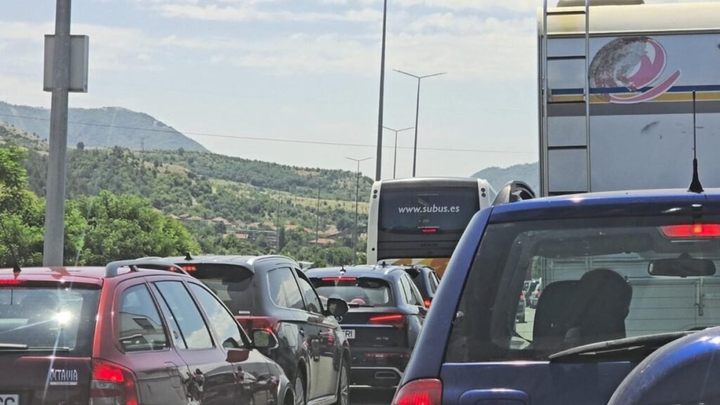 Пробка на болгарской магистрали из легковых машин, автобуса и фургонов на фоне зелёных гор