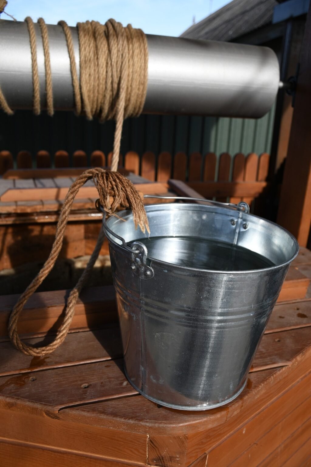 Металлическое ведро с верёвкой на отреставрированном деревянном колодце в заповедной зоне Молдовы